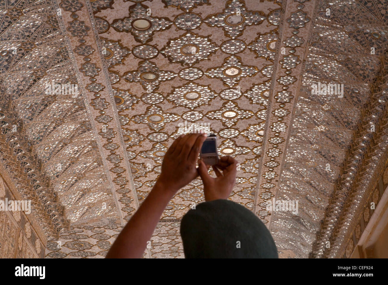 Western traveler photographing ornate arcade decorated with tileworks inside Amber Palace, Jaipur, Rajasthan, India Stock Photo