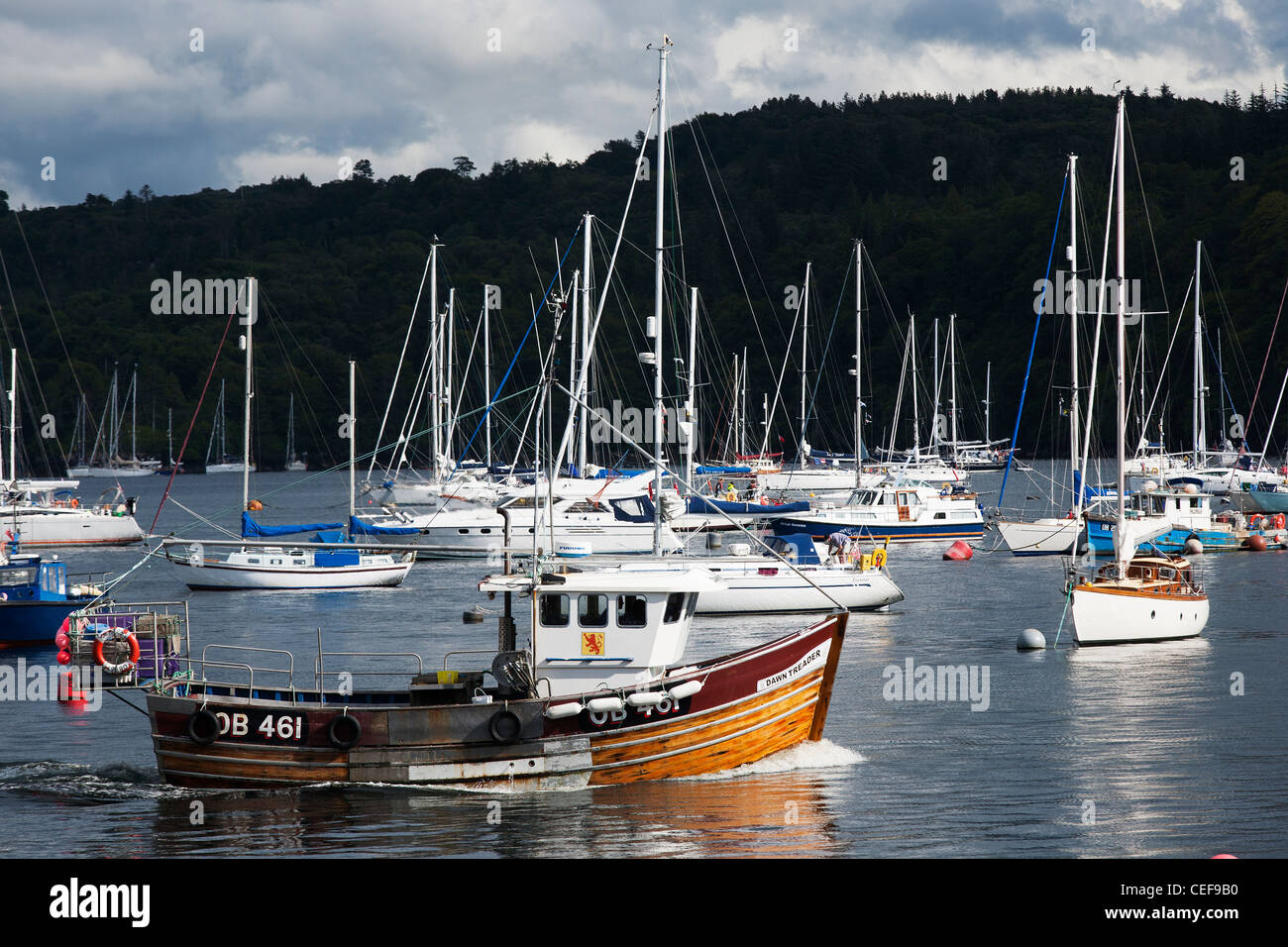 A traditional scottish fishing boat underway through the harbor at