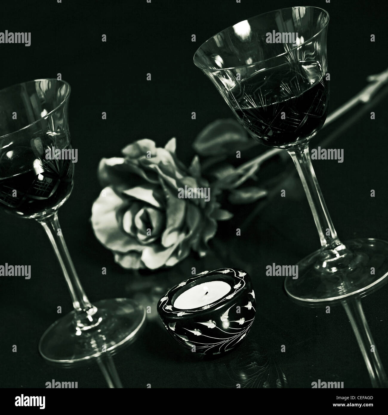 two glasses of red wine with a rose and a candle Stock Photo - Alamy
