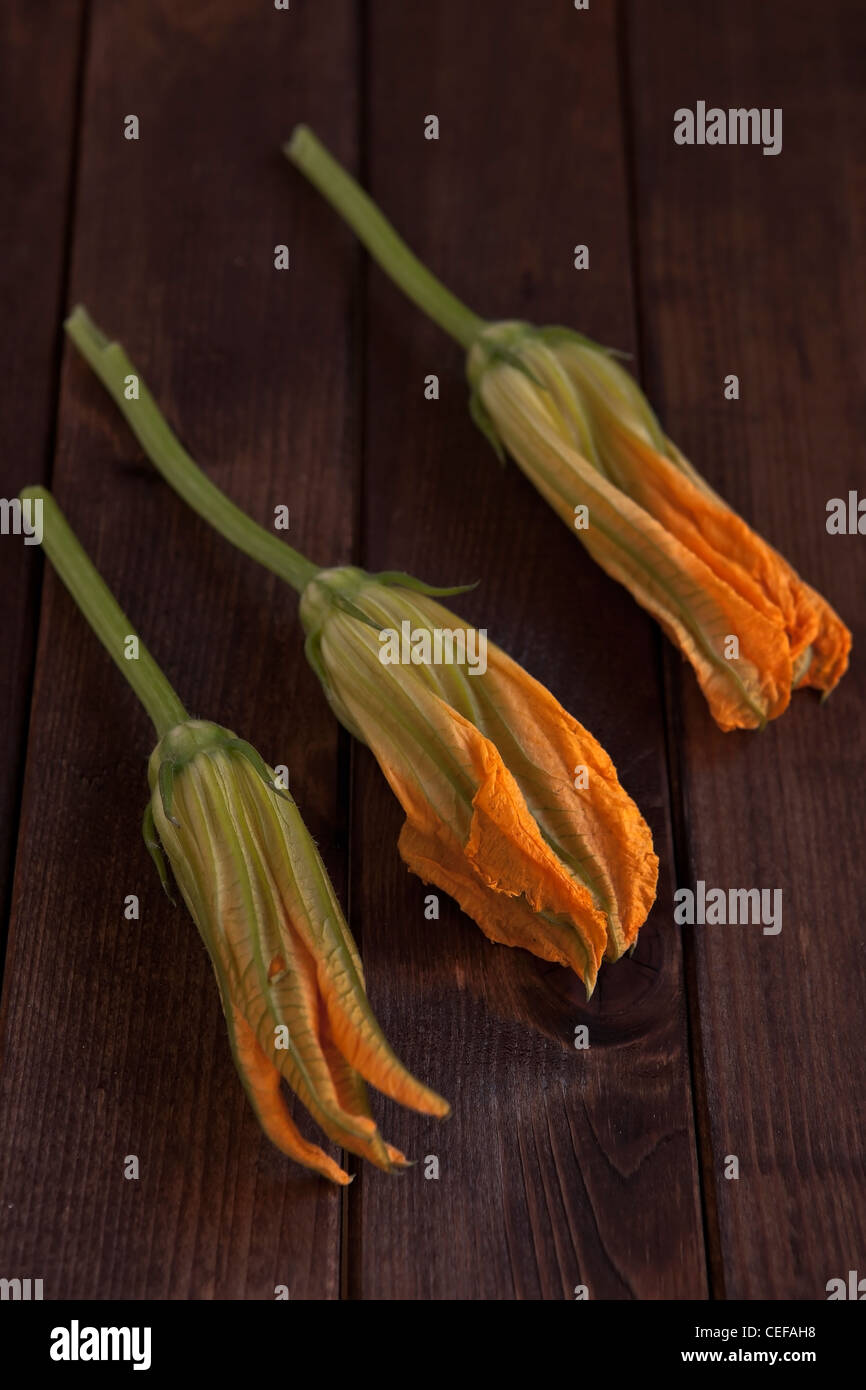 several fresh pumpkin flowers on a wooden table Stock Photo