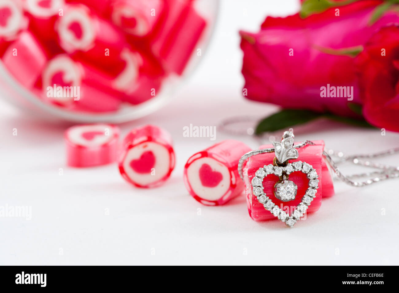 Valentine Series, Diamond pendant and candy with rose on white background Stock Photo