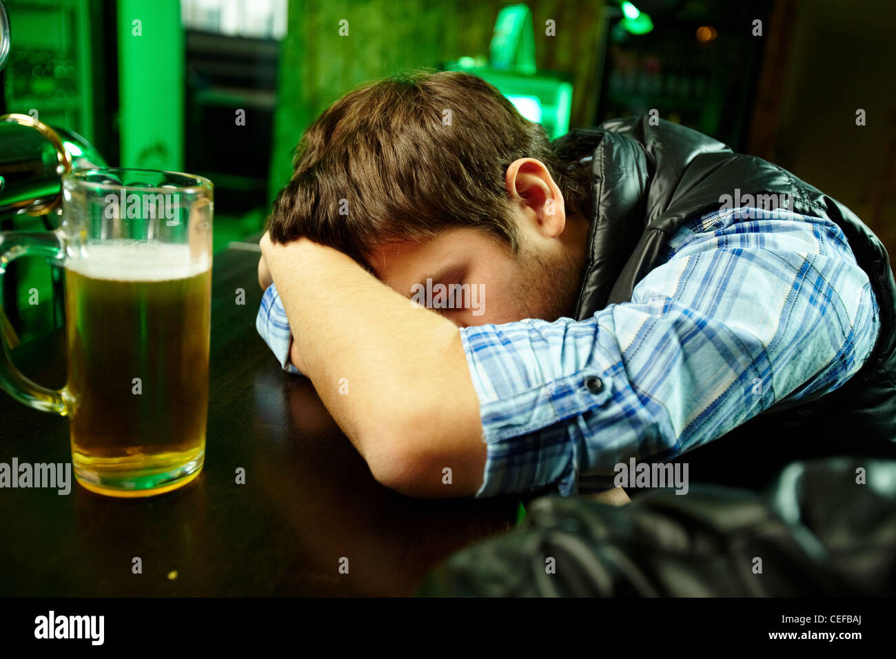 Young man sleeping in pub with glass of beer near by Stock Photo Alamy