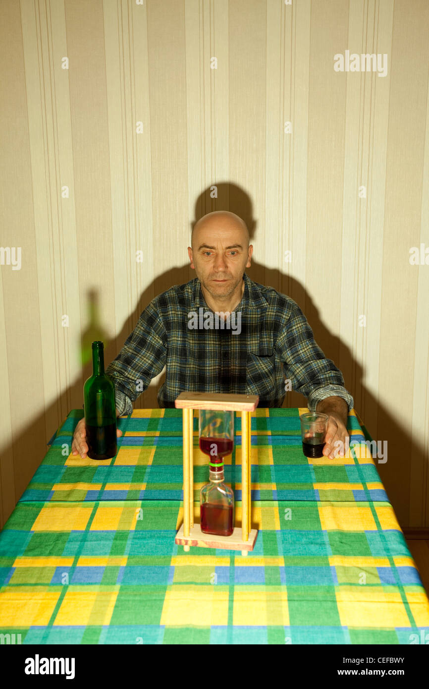 lonely drunken men sit the table with bottle Stock Photo