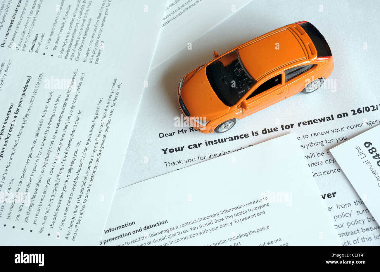 MODEL CAR WITH MOTOR INSURANCE RENEWAL LETTER RE MOTORING INSURANCE COSTS REPAIRS ACCIDENTS RUNNING HOUSEHOLD BILLS RISING UK Stock Photo
