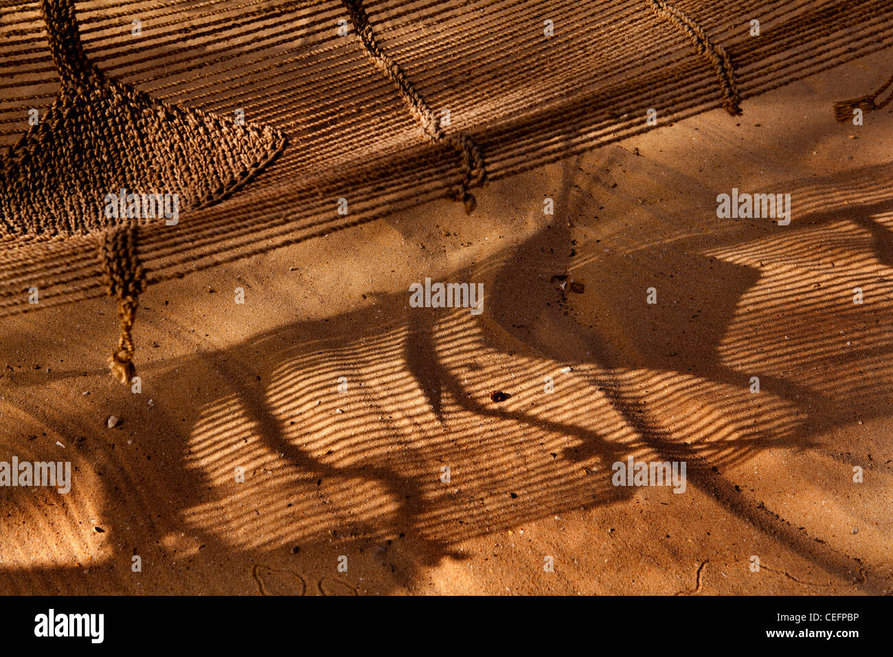 Hammock & shadows on the sand. The Tama Lodge, a luxury hotel in Mbour, Senegal. Stock Photo