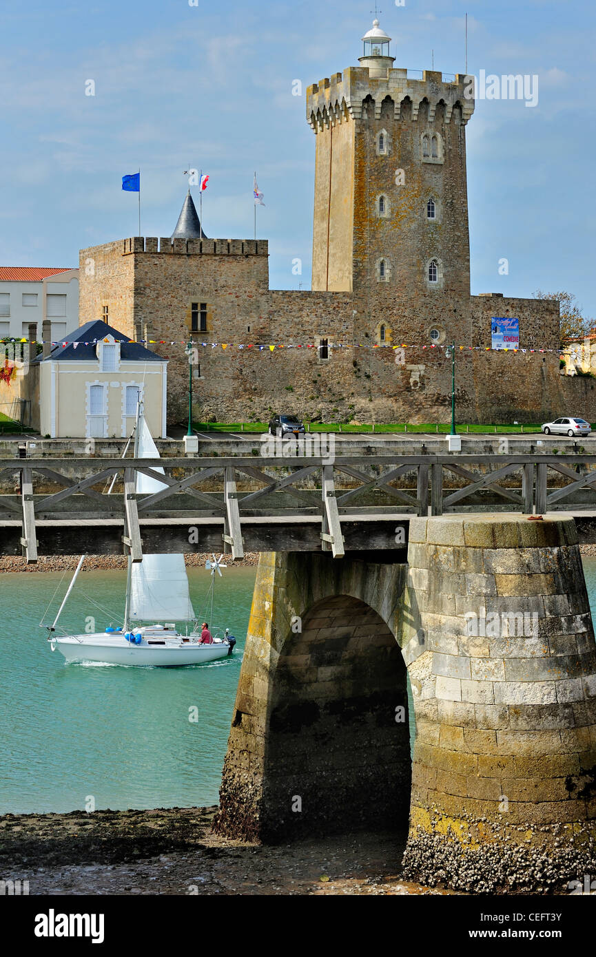 Sailing boat passing the castle / lighthouse château Saint-Clair at Les Sables-d'Olonne, La Vendée, Pays de la Loire, France Stock Photo