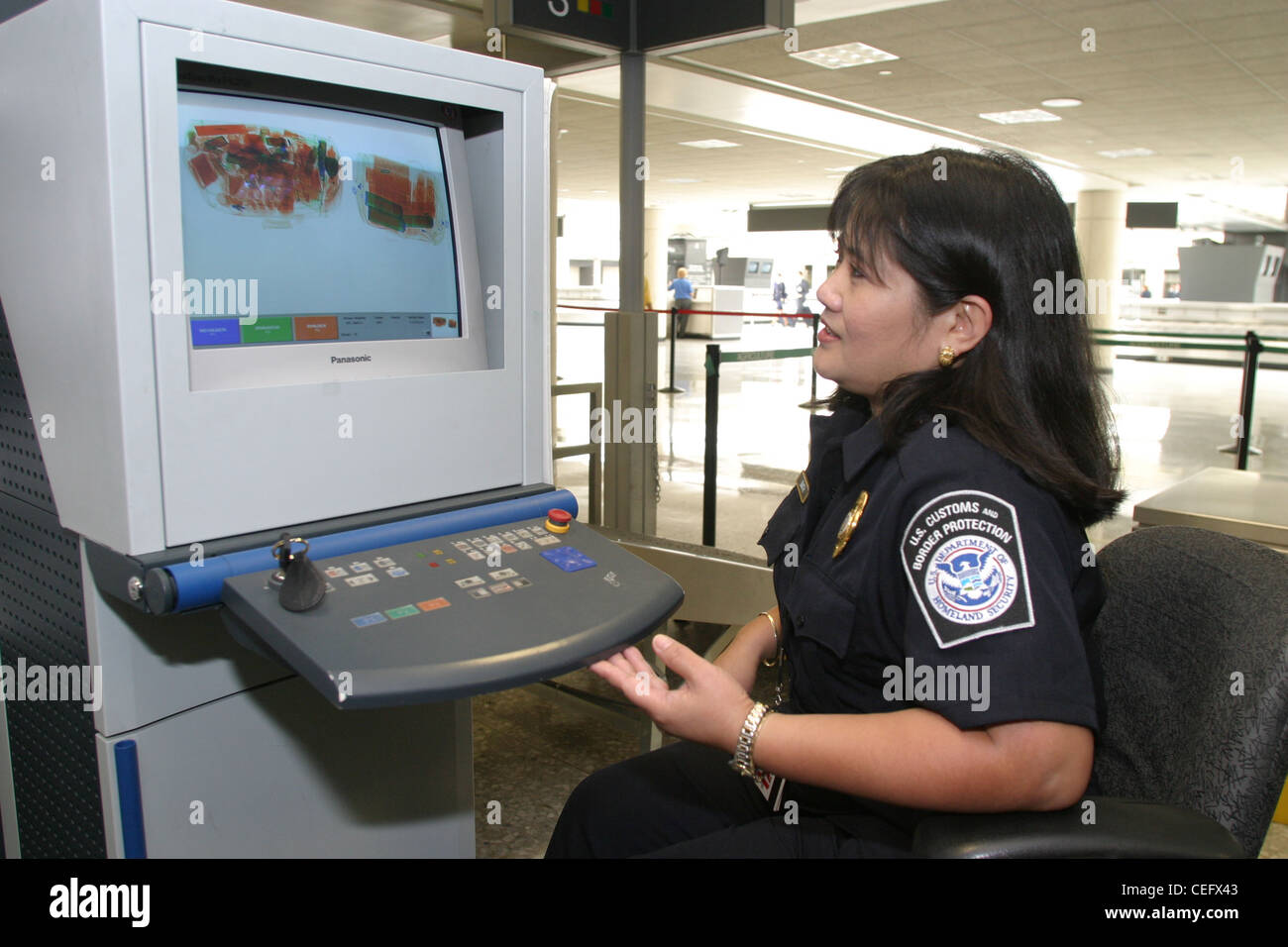 Using a highly sophisticated scanner a CBP Officer looks for organic and inorganic materials that could be considered dangerous. Stock Photo