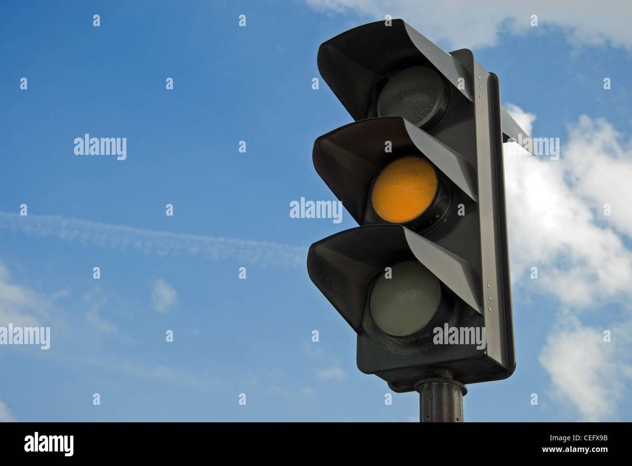Amber color on the traffic light with a beautiful blue sky in