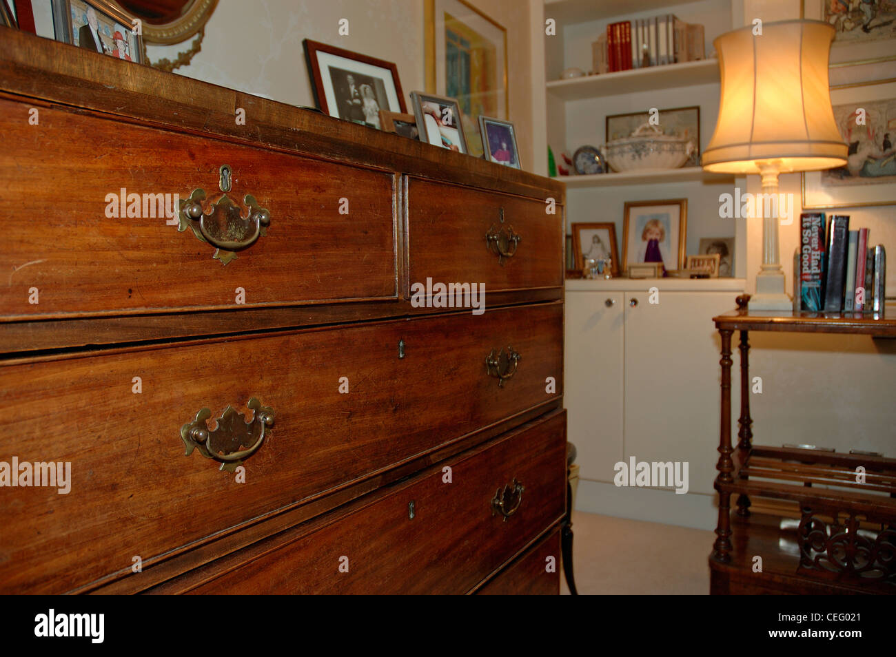 Victorian mahogany chest of drawers and lighted lamp in corner of