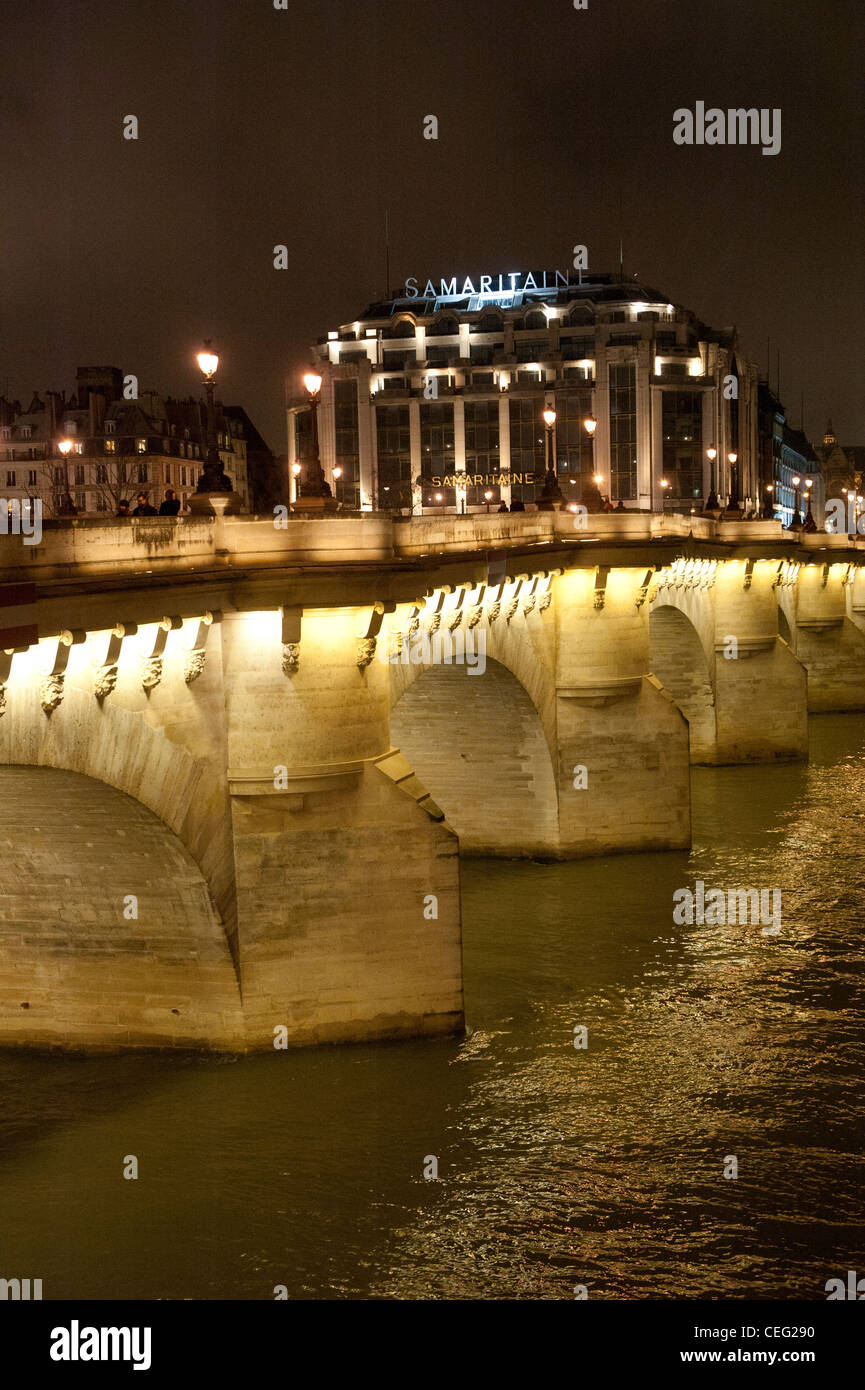 Illuminated Pont Neuf, the Seine, and the La Samaritaine building at night in the district of first district Paris Stock Photo