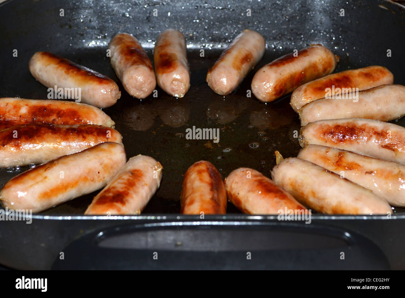 sausages cooking in fry pan Stock Photo