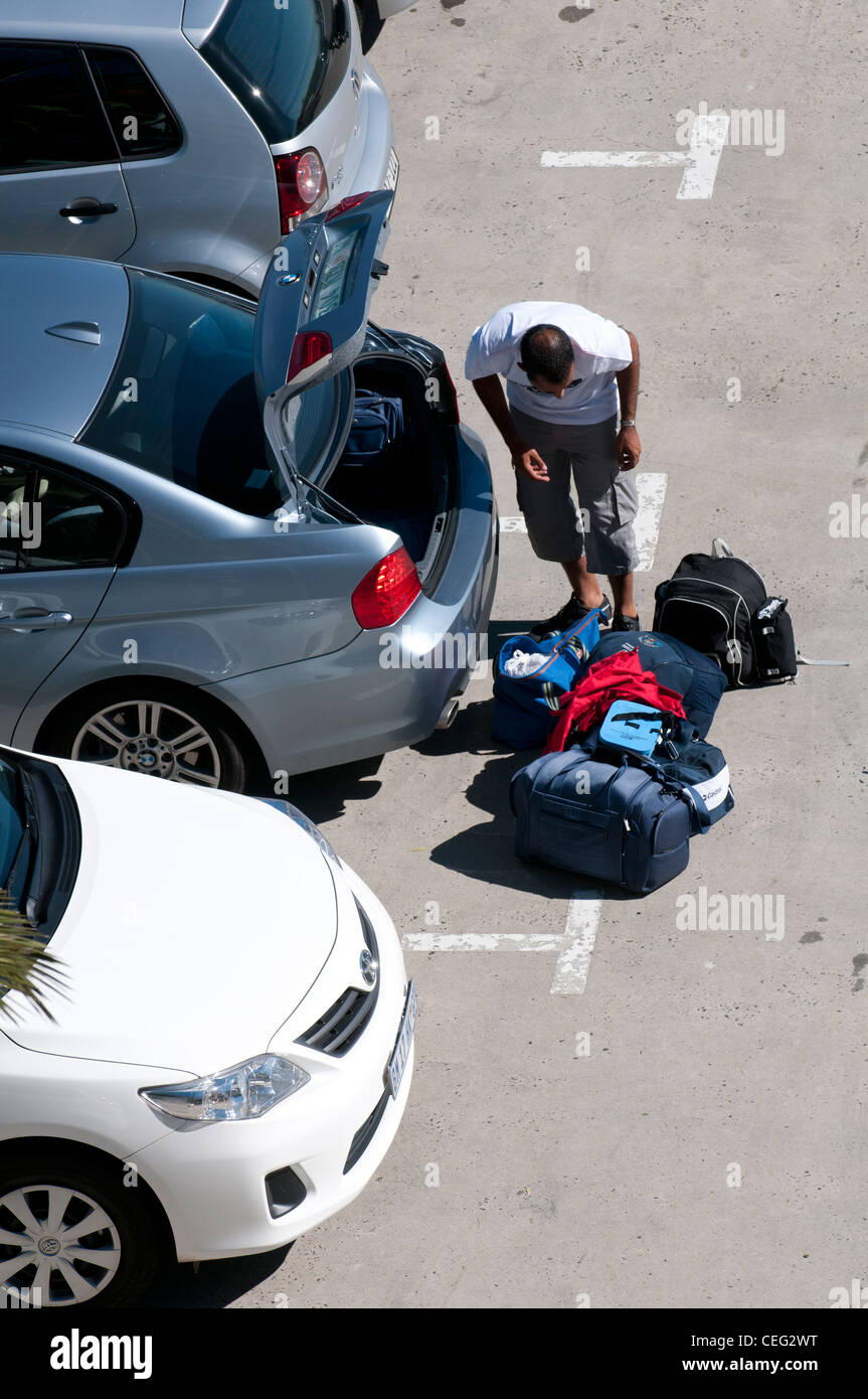 Man packing luggage into car boot Stock Photo - Alamy