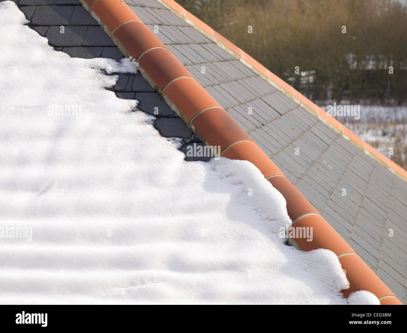 A close-up photo of melting or thawing snow on a tiled roof. Stock Photo