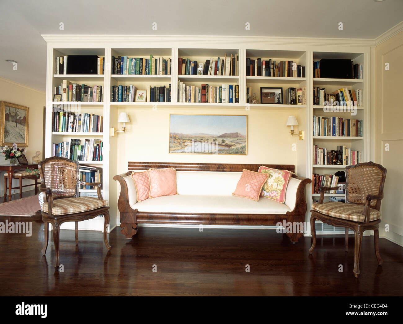 French-style sofa and armchairs in front of alcove book shelves in  traditional living room with dark wood flooring Stock Photo - Alamy, image size:1300x1044