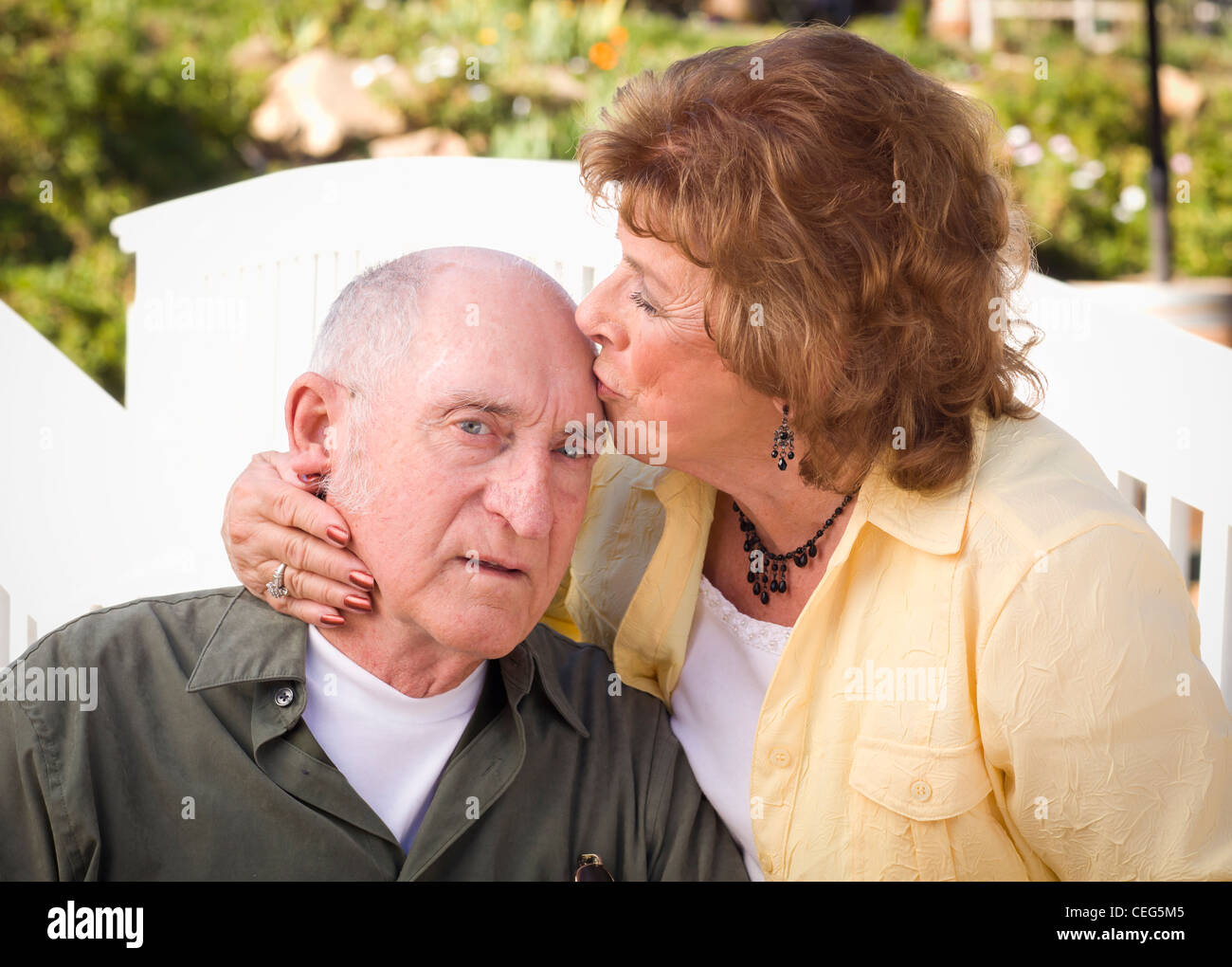 Happy Senior Couple Kissing in the Park. Stock Photo