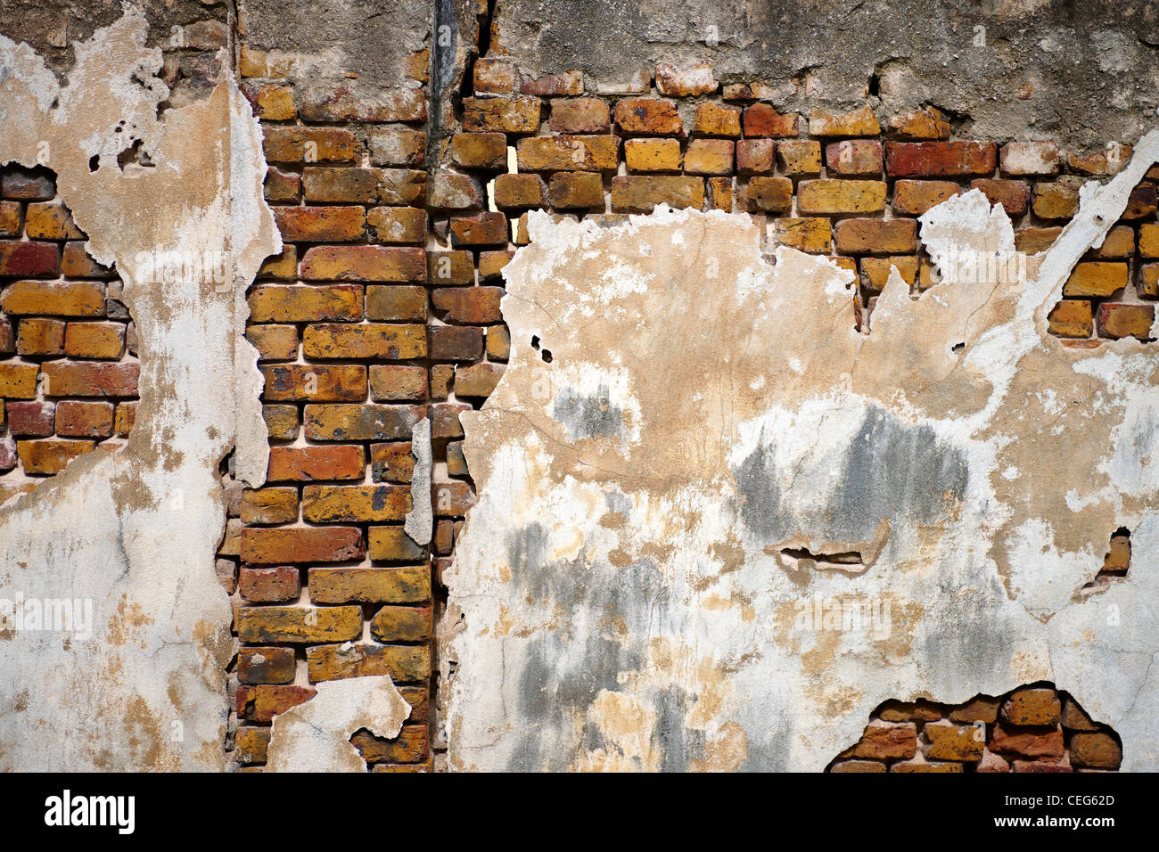 old weathered brick wall with peeling plaster Stock Photo