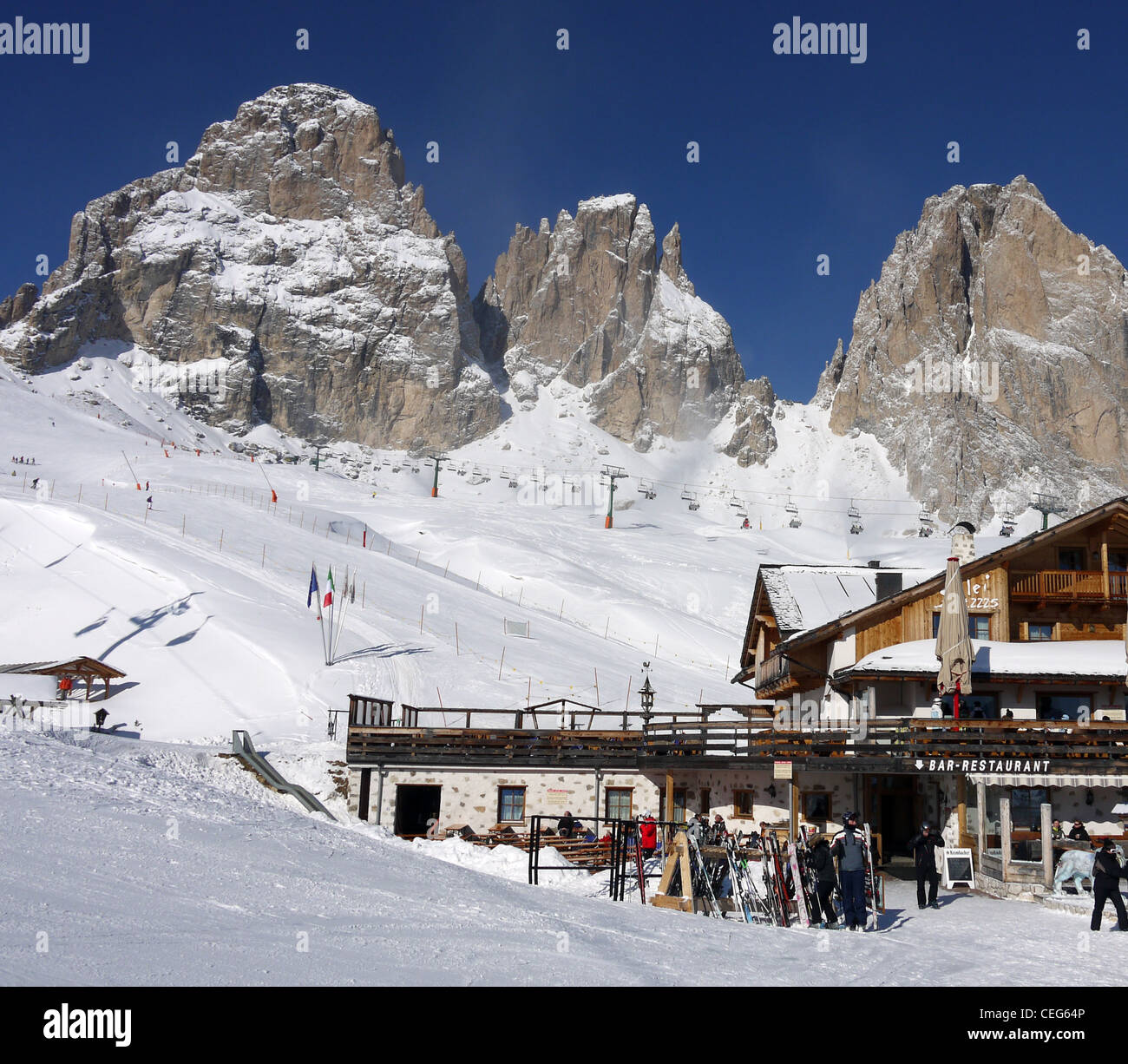 Restaurant on the piste with the towering Dolomite mountains behind on the Sellaronda ski circuit Stock Photo