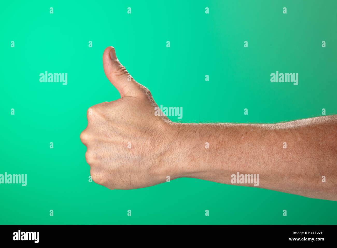 Thumbs Up OK Signal on Green Background Stock Photo