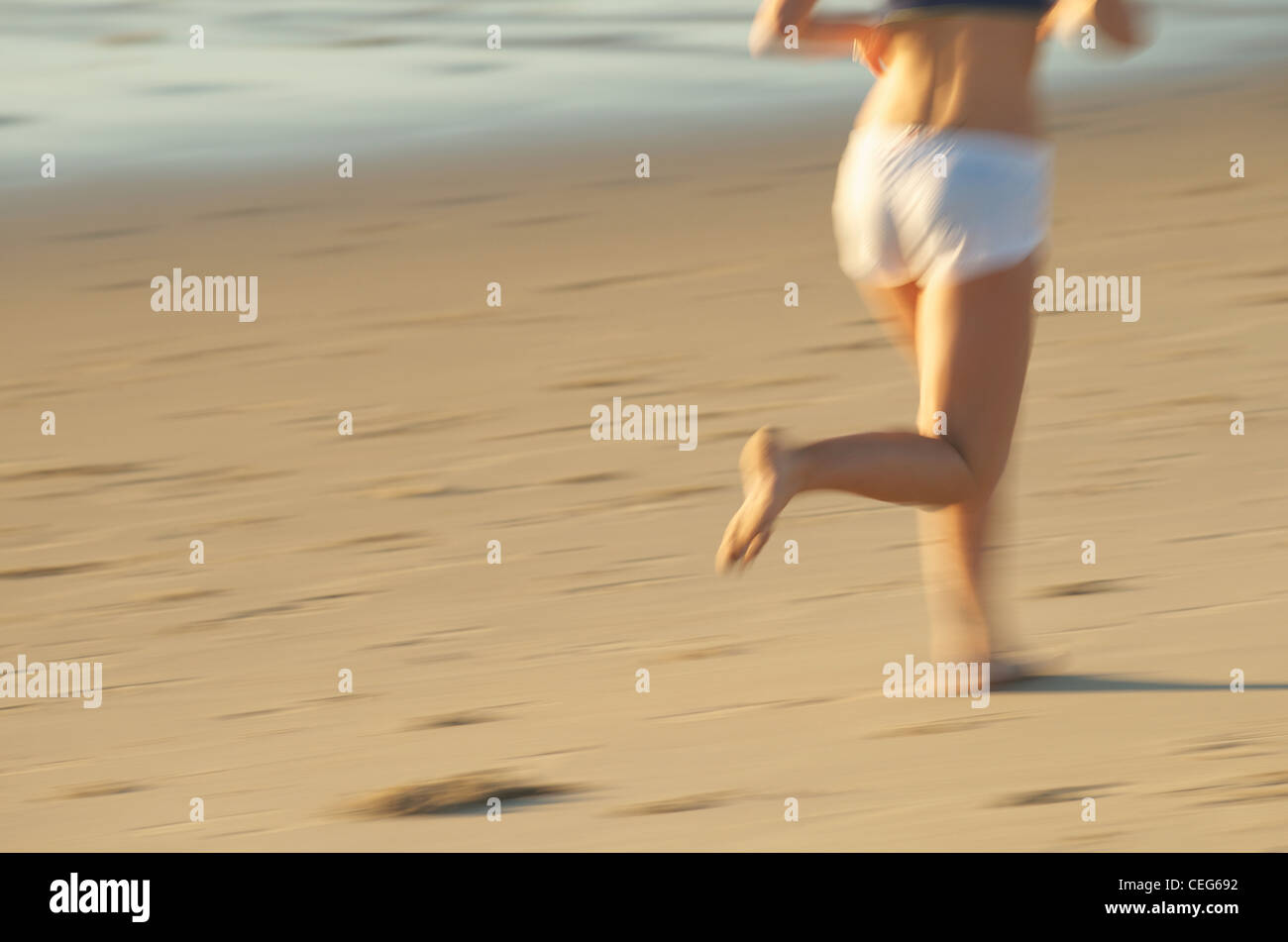 A woman running on the beach. Stock Photo