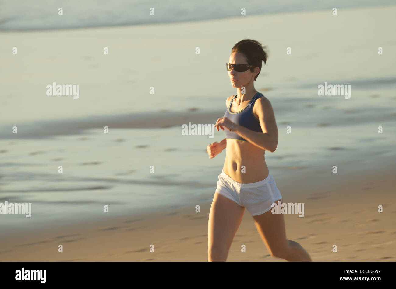 A woman running on the beach. Stock Photo