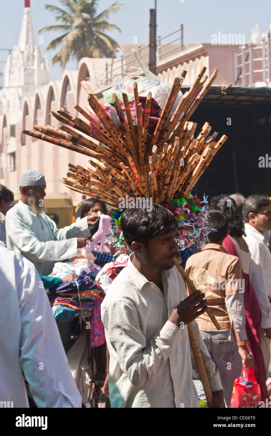 Indian peddler sells flutes whistles and toys in Bangalore's busy