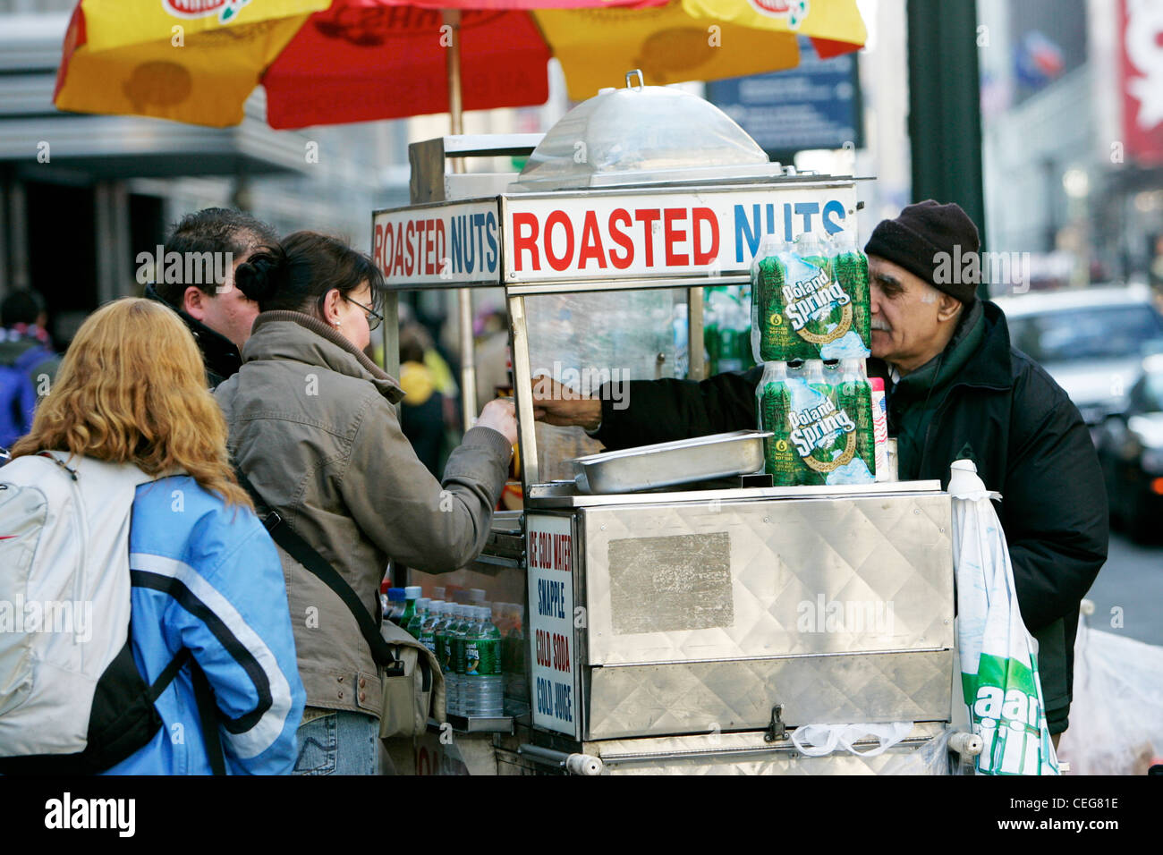 street vendor selling roasted nuts to tourists on street corner new