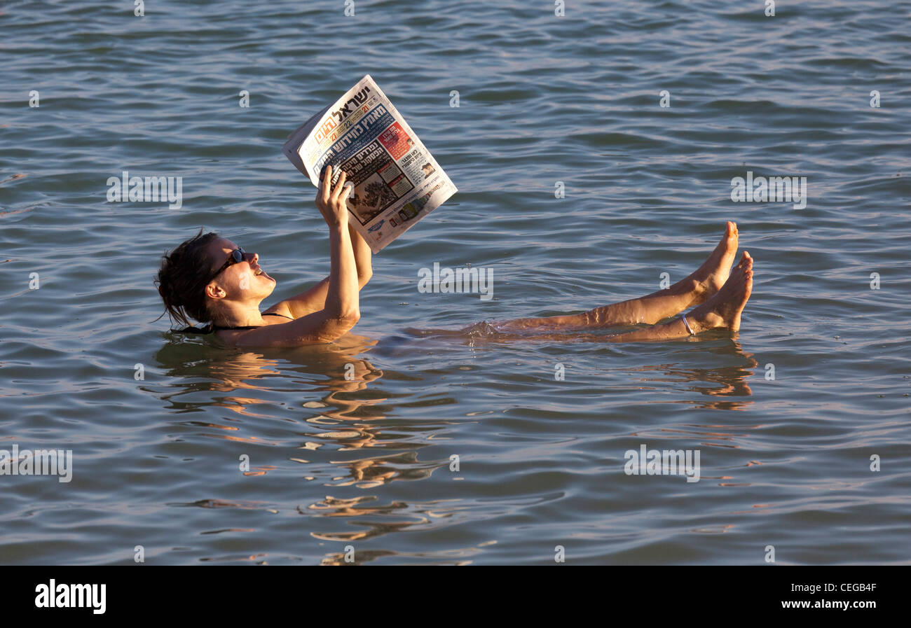 A woman floating in the Dead Sea reading a newspaper Stock Photo Alamy