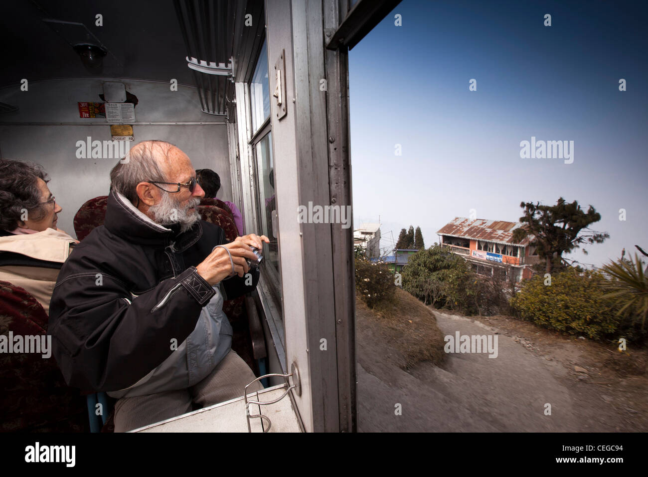 India, West Bengal, Darjeeling Himalayan Mountain Railway train passenger photographing passing scenery Stock Photo