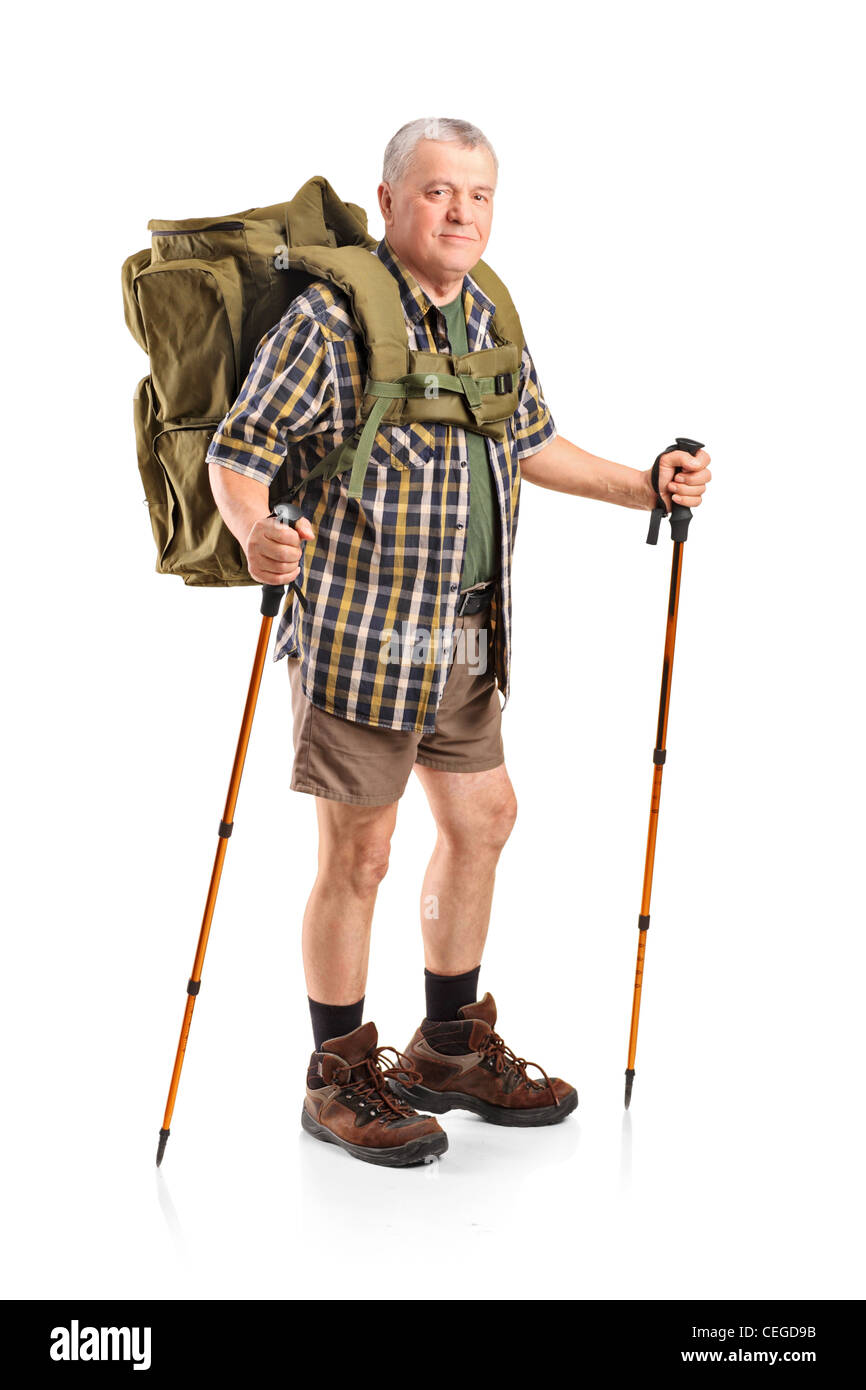 Full length portrait of a smiling mature with backpack holding hiking poles posing isolated on white background Stock Photo