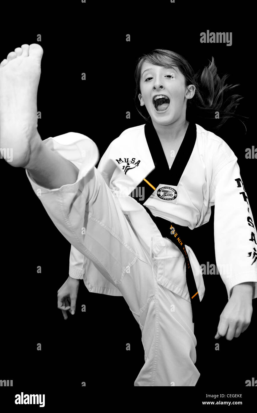 a young girl does a taekwondo axe kick Stock Photo