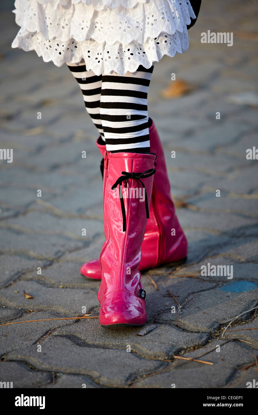 Trendy and fashionable girl in pink boots and striped leggings Stock Photo