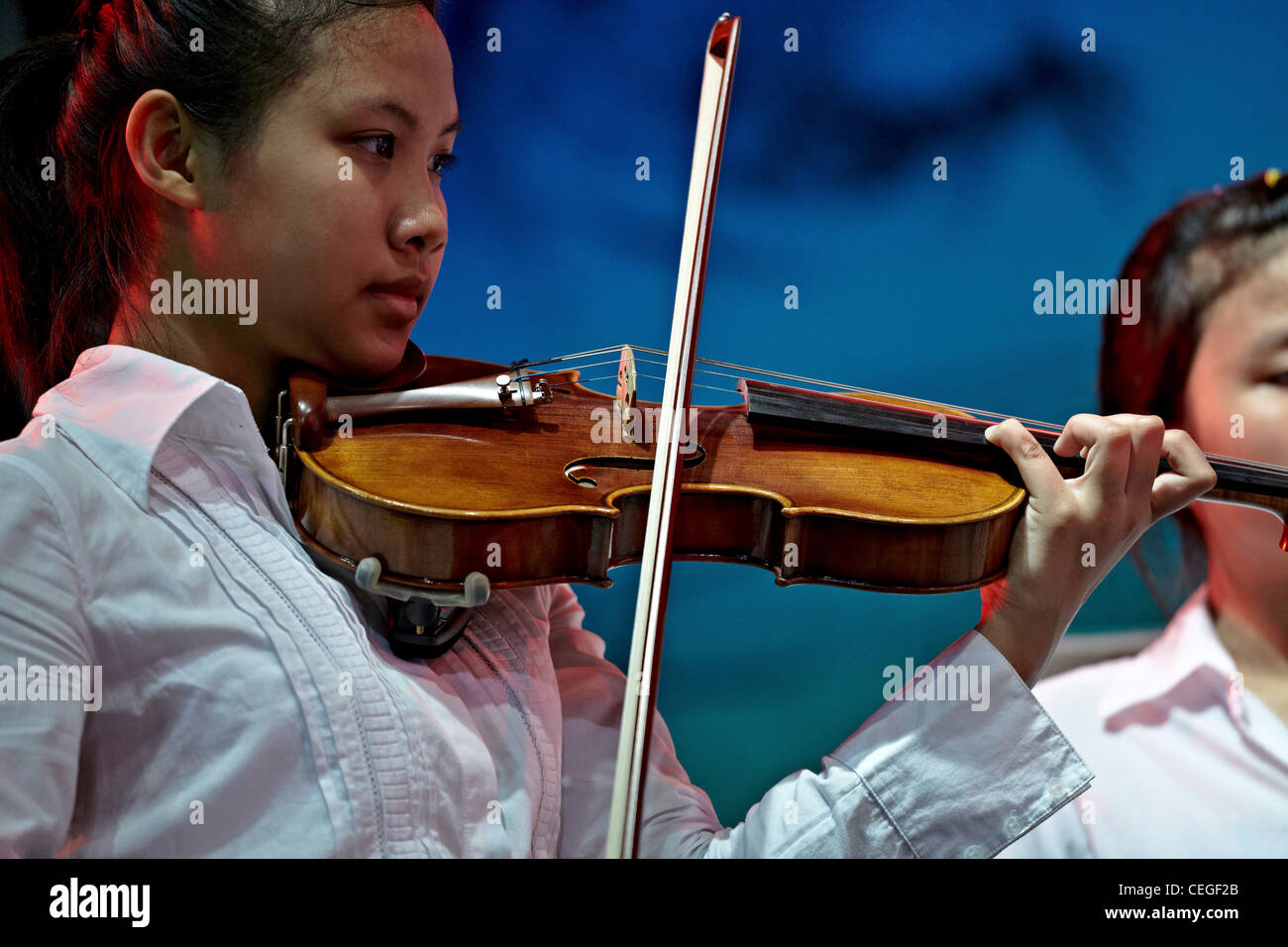 Girl playing violin on stage Stock Photo
