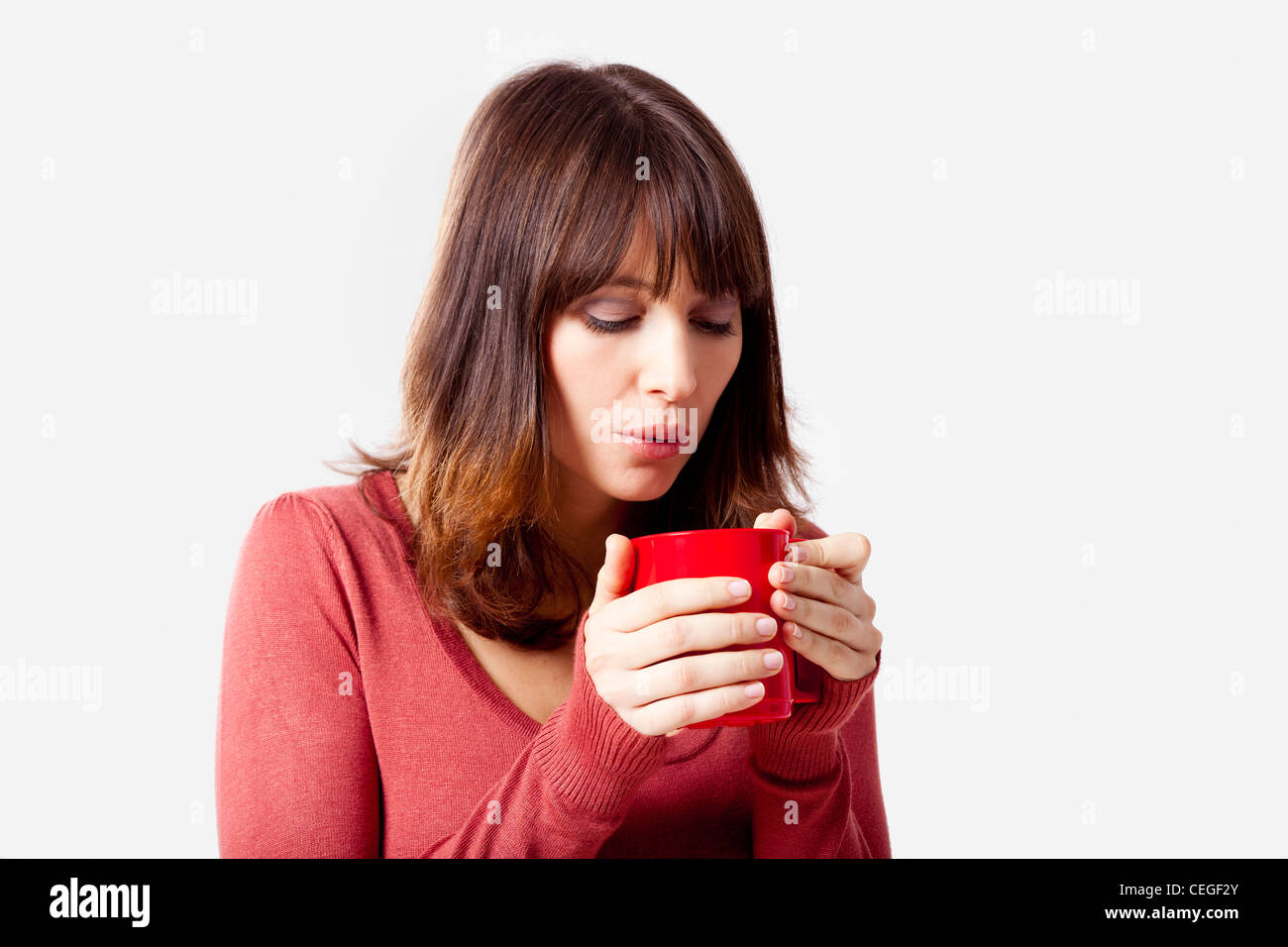 Beautiful young woman holding a cup of coffee, isolated on a gray ...
