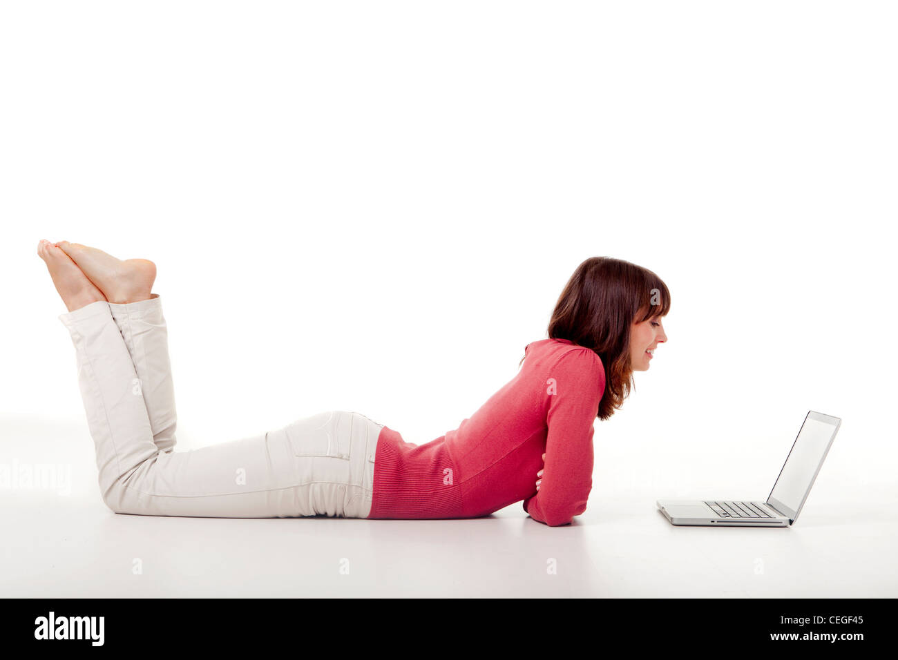 Beautiful woman lying on the floor and working with a laptop Stock ...