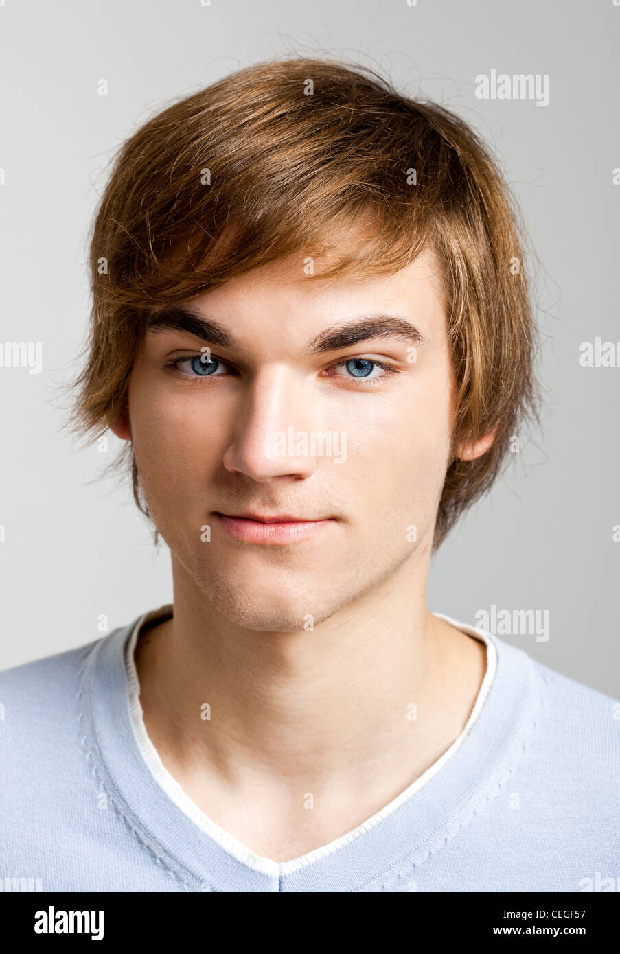 Portrait of a handsome young man over a gray background Stock Photo - Alamy