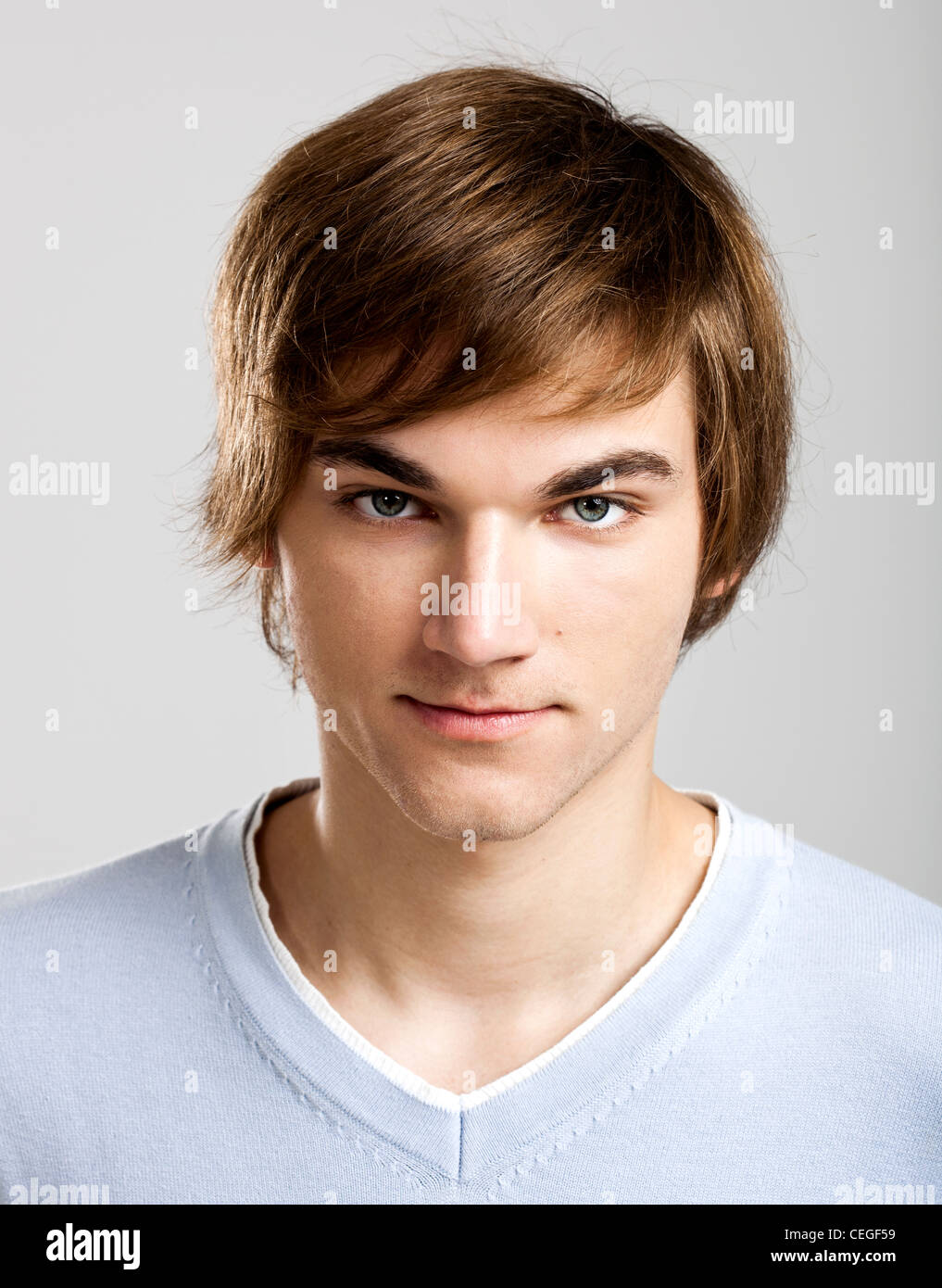Portrait of a handsome young man over a gray background Stock Photo - Alamy
