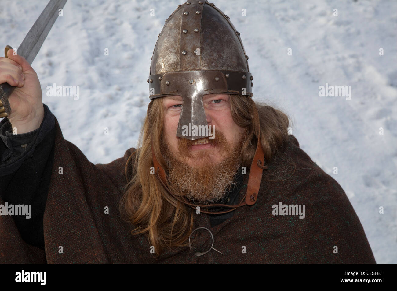 Viking re-enactor, with beard & long hair wearing Helmet and carrying sword at the 27th Annual JORVIK Festival in York, UK Stock Photo