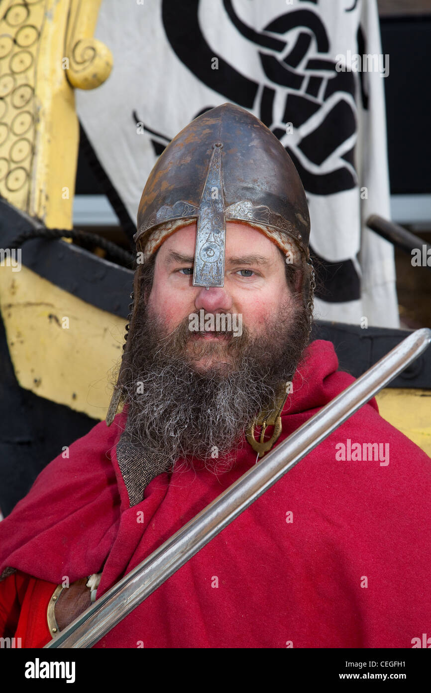 Bearded armed Viking re-enactor wearing Helmet and carrying sword weapon at the 27th Annual JORVIK Festival in York, UK Stock Photo