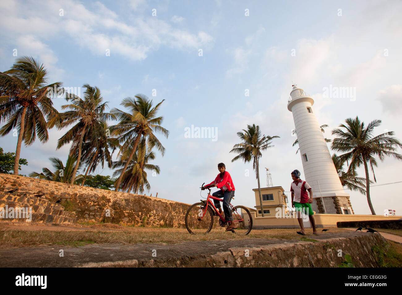 People walking and cycling lighthouse old town, The Fort Galle Sri Lanka Asia Unesco World Heritage Site Stock Photo