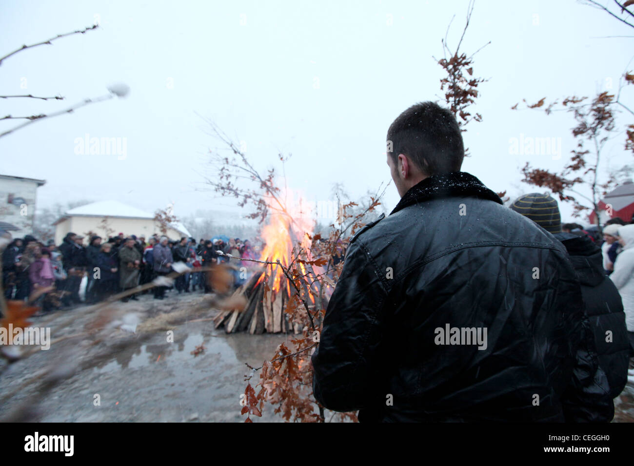 Man waiting to place wood on the public campfire during orthodox christmas celebration in Mojkovac, Montenegro, Balkans Stock Photo