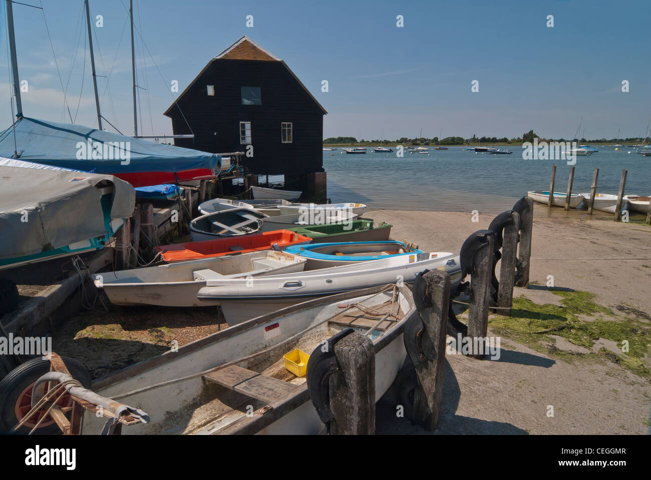 The boat shed at Bosham Quay with coloured boats arranged in front