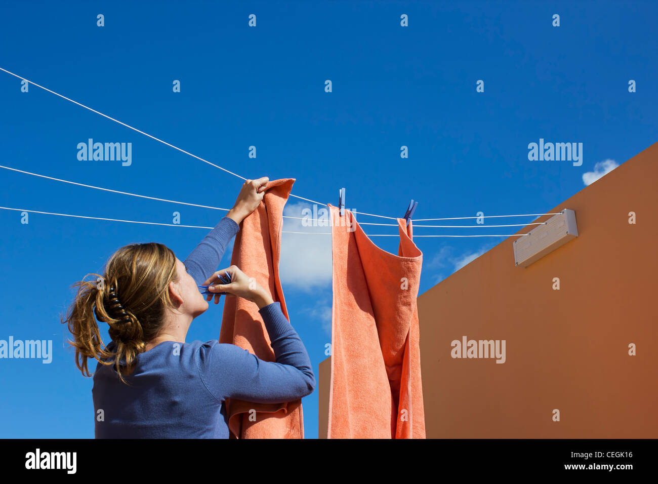 Young woman pegging out washing to dry. Stock Photo