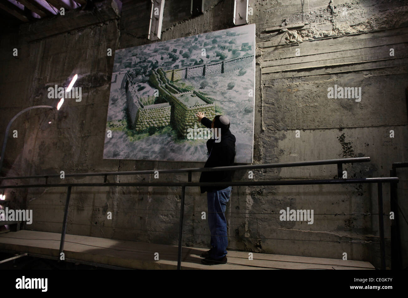 An Israeli tour guide describes the story of ancient Jerusalem fortifications with the assistance of a chart at the ancient underground Hezekiah's Tunnel or the Siloam Tunnel in Ir David or City of David the archaeological site which is speculated to compose the original urban core of ancient Jerusalem in Israel Stock Photo