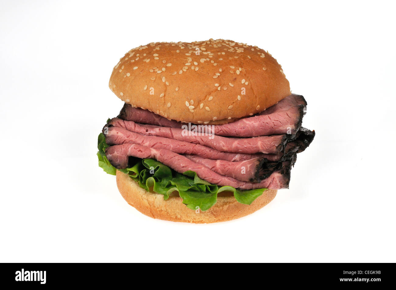 Roast beef sandwich on sesame seed  bread roll on white background cutout. Stock Photo