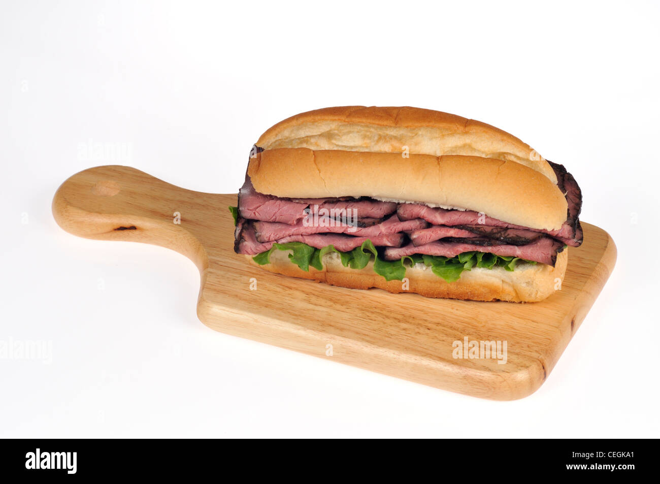 Roast beef with lettuce and tomato salad sandwich in bread submarine roll on wood deli board on white background isolated Stock Photo