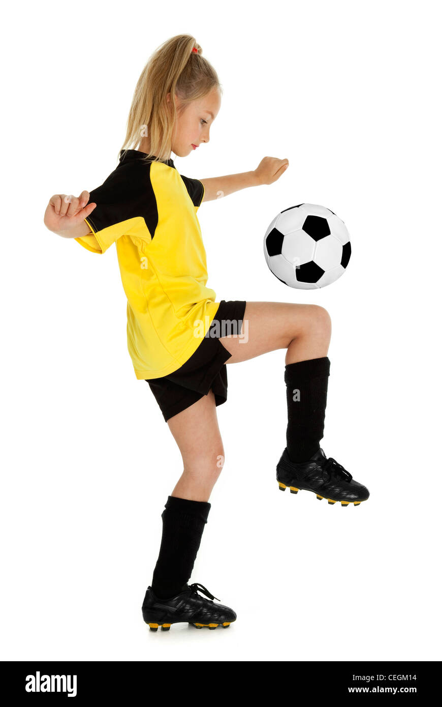 Full length side view of eight year old girl with soccer ball, isolated