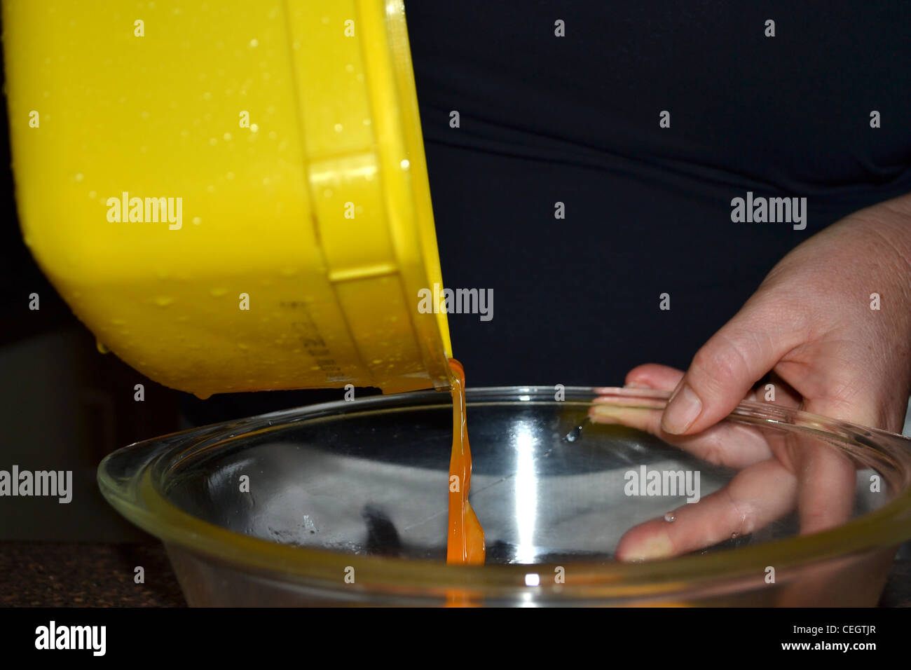 Pouring egg into mixing bowl Stock Photo