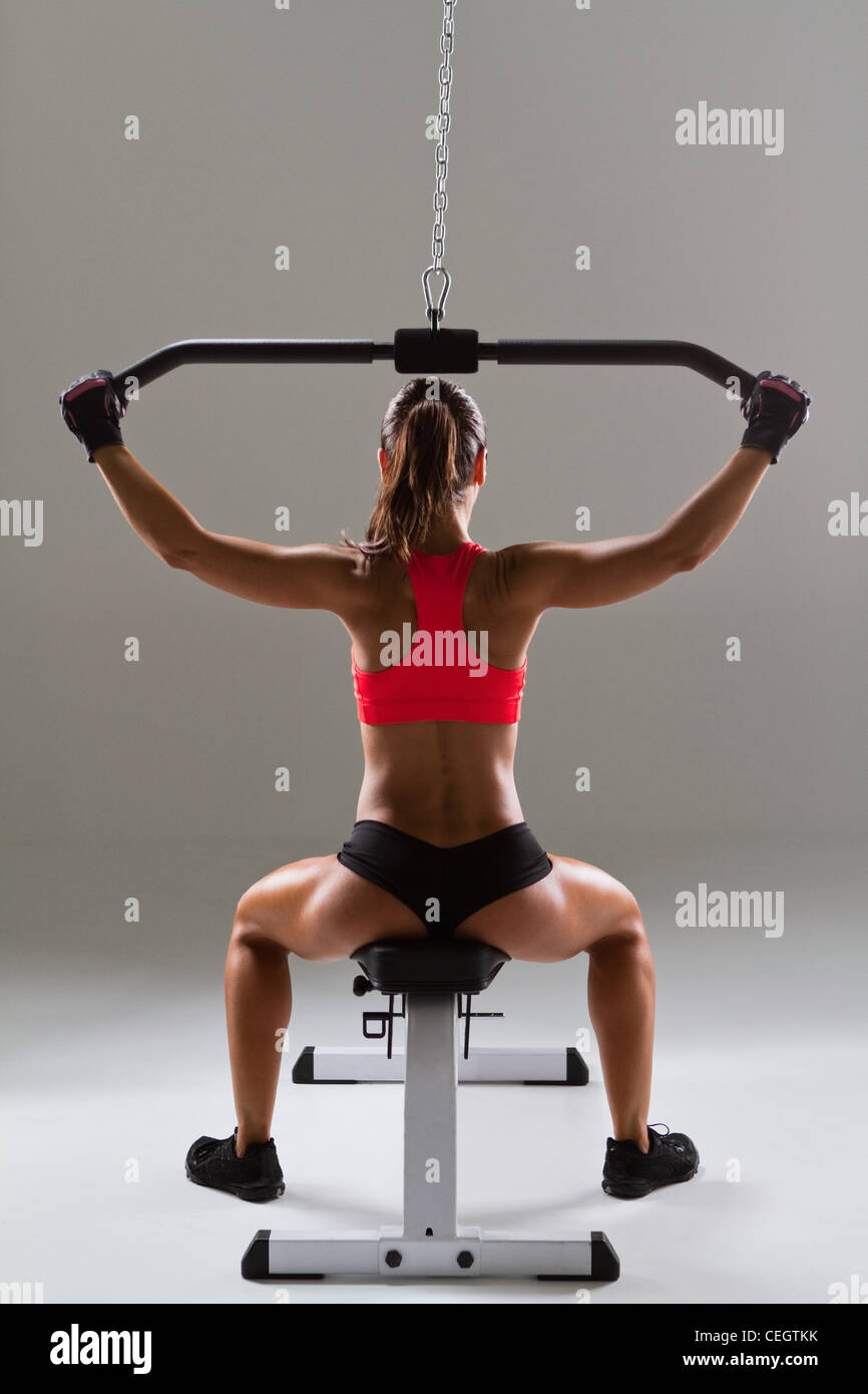 Female weightlifter using weight machine Stock Photo