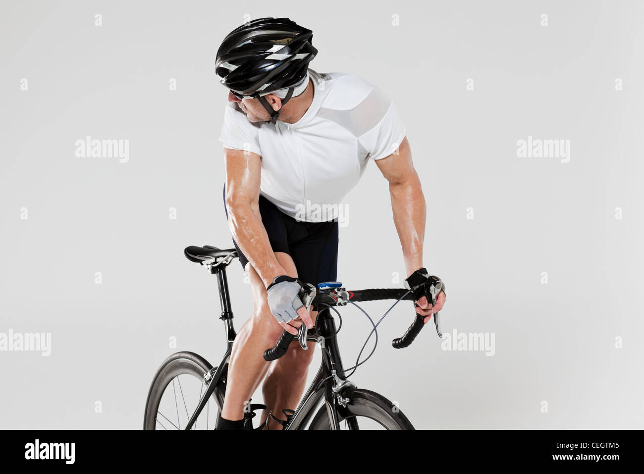 Male cyclist looking over shoulder Stock Photo