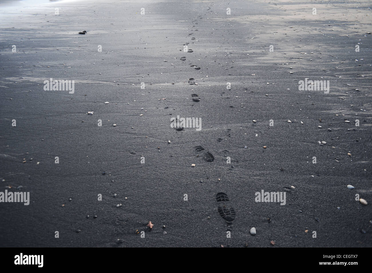 Footprints are left on deposits of sea coal on a beach in Saltburn, Cleveland Stock Photo